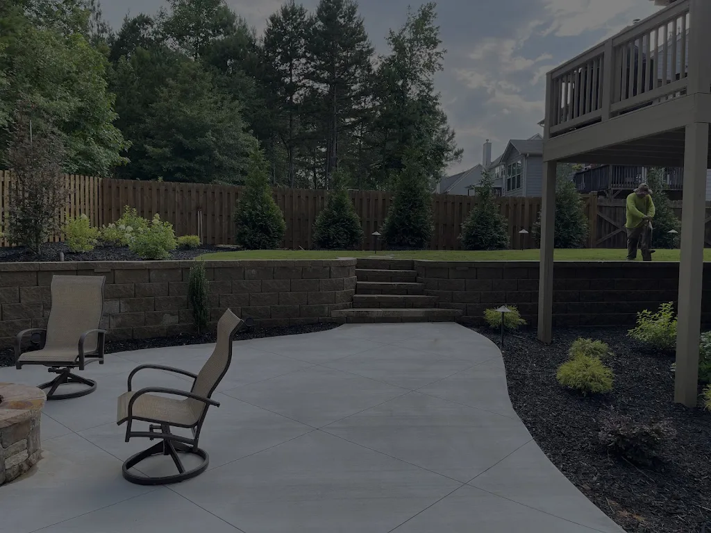 A residential property with a well-maintained lawn, trees, and shrubs. A white Canelo Landscape & Design truck is parked in the driveway.